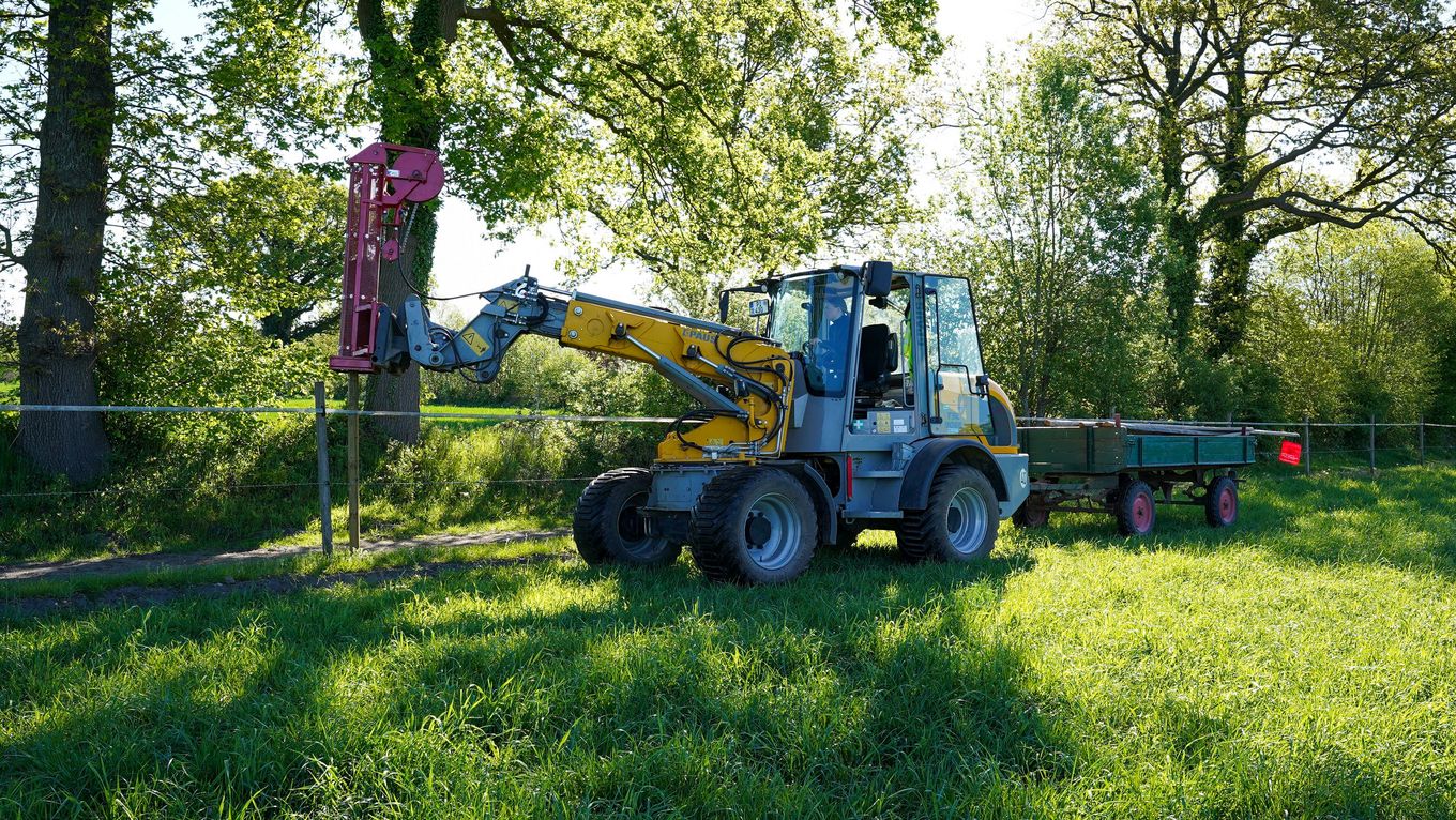 A pile driver has been mounted on a Paus telescopic swing loader, which is being used to fence in a horse pasture.